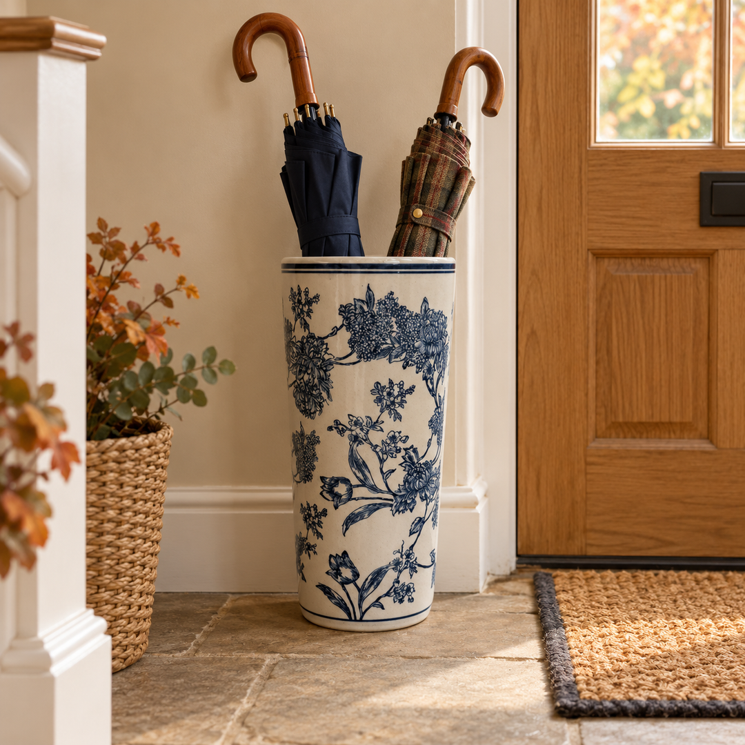 Blue and white magnolia umbrella stand with umbrellas in a hallway