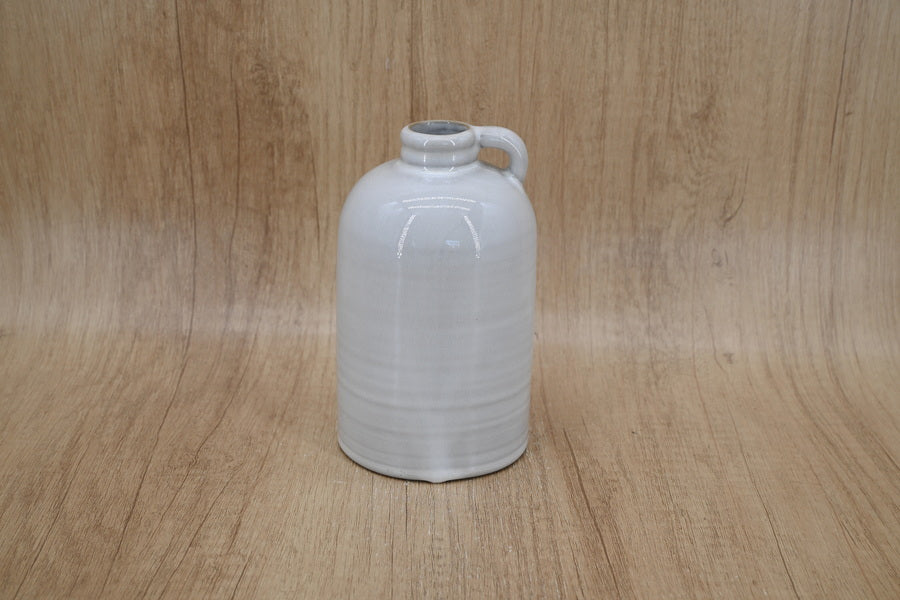 Short white jug-shaped vase on a wood backdrop
