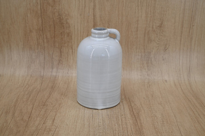 Short white jug-shaped vase on a wood backdrop