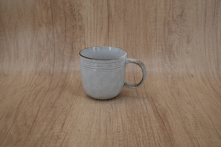 Pale grey ridged stoneware mug photographed against a wood-effect backdrop
