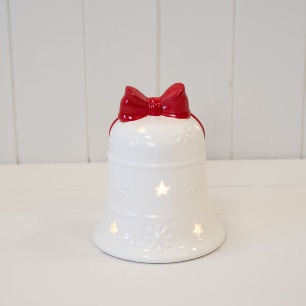 White Christmas bell with red bow, shown illuminated