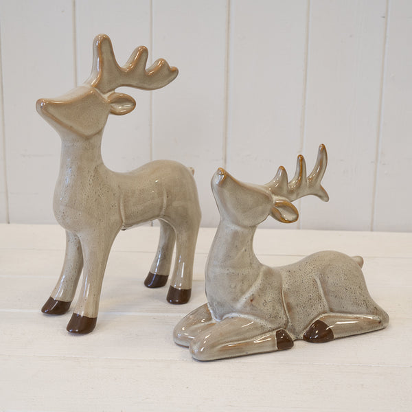 Standing and reclining reindeer ornaments pictured together