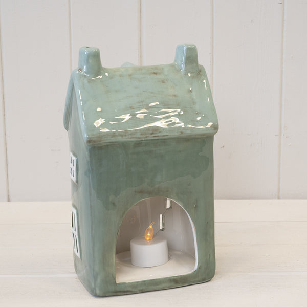 Rear opening of green house tealight holder with a lit tealight shown