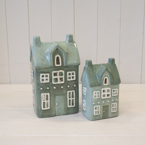 Two green house tealight holders in different sizes pictured together