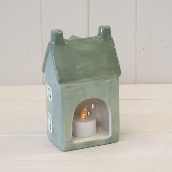 Rear opening of green house tealight holder with a lit tealight shown