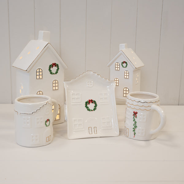 White Christmas houses, house plate and mugs displayed together
