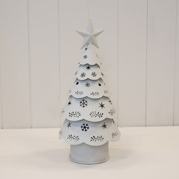 Off-white metal Christmas tree unlit, showing its star and snowflake cut-outs