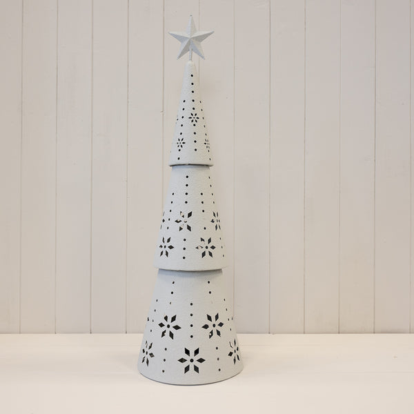 Tall off-white metal Christmas tree unlit, showing snowflake cut-out details
