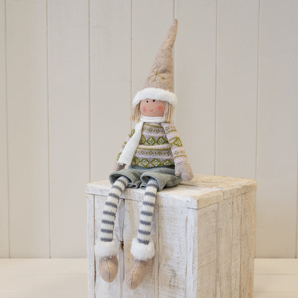 Fabric boy figure in natural and grey winter sweater seated on a wooden plinth